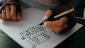 Hand sketching a website wireframe on paper before development